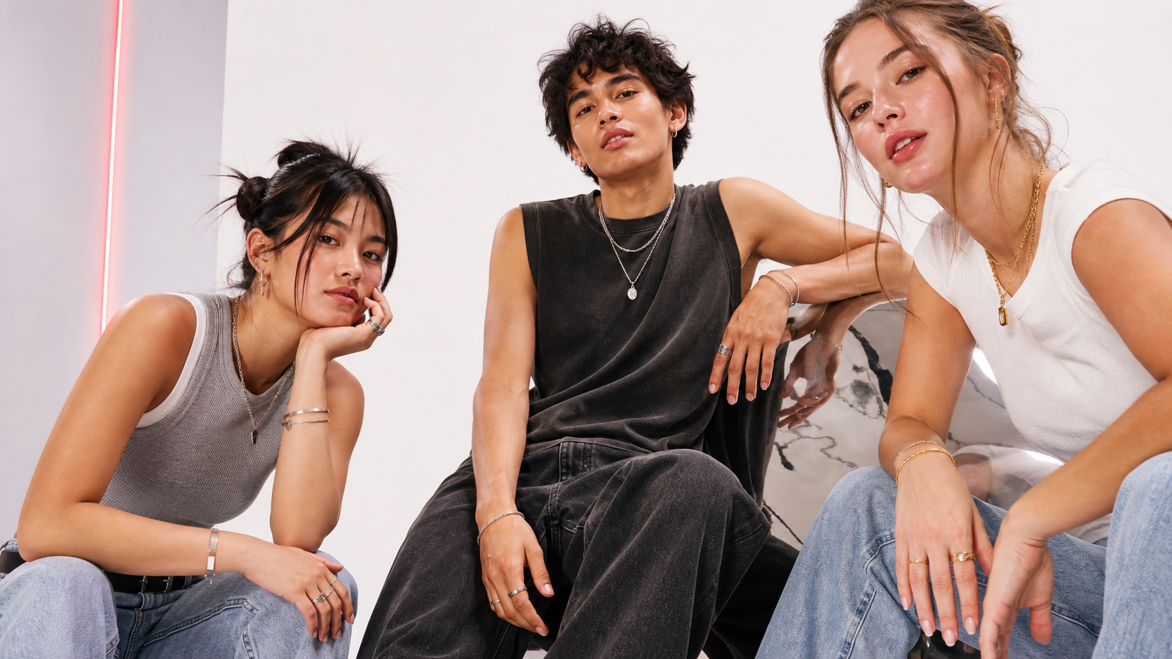 Three friends wearing mixed gold and silver Odd Crane jewelry
